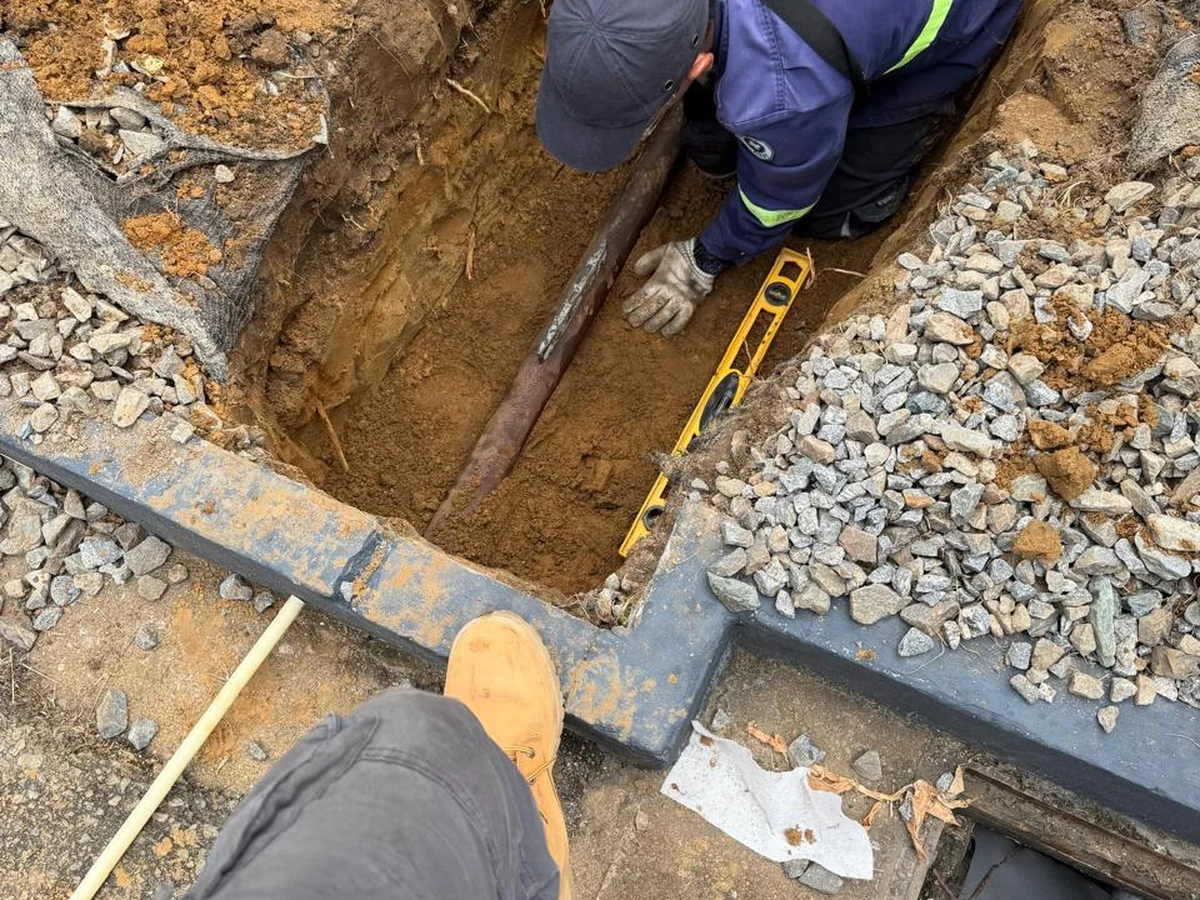 Technicus in een sleuf tijdens ondergrondse infrastructuurwerkzaamheden